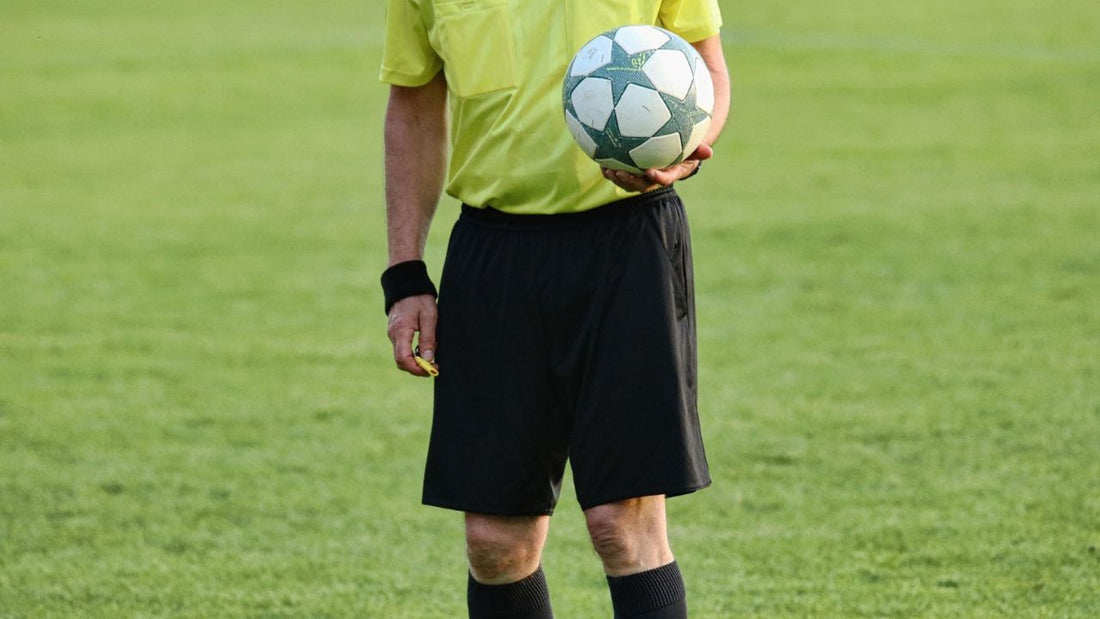 Soccer referee holding a ball on the field