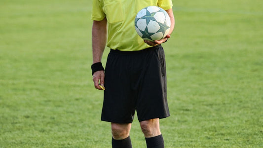Soccer referee holding a ball on the field